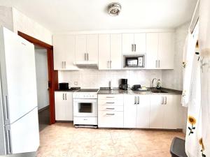een keuken met witte kasten en een witte kookplaat bij Vibes Coruña-Filipinas 4 in A Coruña