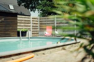 uma piscina com uma cadeira rosa e uma piscina em Hotel Lamperse Hei em Wanroij