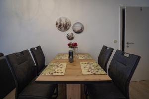 a dining room table with chairs and a table with flowers at Ferienwohnung Saaletal in Naumburg