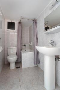 a bathroom with a sink and a toilet and a tub at Hotel Roumani in Spetses