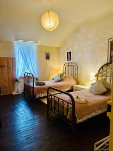1 dormitorio con 2 camas y lámpara de araña en Les Contes, en Fougax-et-Barrineuf