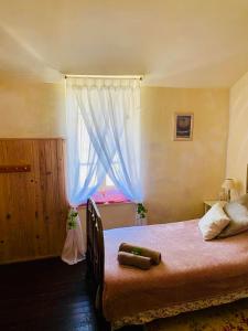 sypialnia z dużym łóżkiem i oknem w obiekcie Les Contes w mieście Fougax-et-Barrineuf