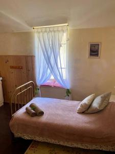 a bedroom with a large bed with a window at Les Contes in Fougax-et-Barrineuf