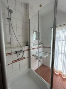 een badkamer met een douche en een wastafel bij Ferienwohnung "Seeschwalbe" in Hagermarsch