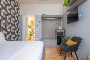 ein Schlafzimmer mit einem Bett und einem Stuhl sowie eine Küche in der Unterkunft Suites Romae Rex in Rom