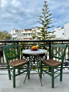 uma mesa e duas cadeiras com uma fruta na varanda em Ammosis Inn em Naxos Chora