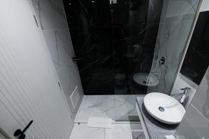 een badkamer met een wastafel, een douche en een toilet bij Royal G Max in Golem