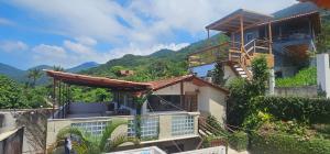 a house on a hill with mountains in the background at Pousada Encontro das Águas in Trindade
