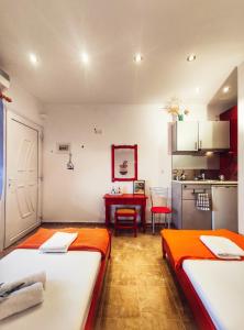 Zimmer mit 2 Betten und einer Küche mit einem Tisch in der Unterkunft Rena's Rooms Μελίντα in Melínta