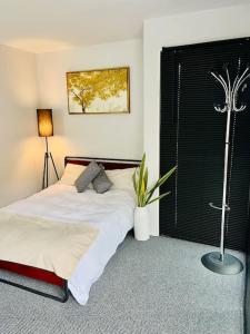 East Bridgford Summerhouse Inc Spa and Treatments في East Bridgford: غرفة نوم يوجد عليها سرير وزرع