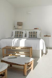 - une chambre avec un lit, un banc et une table dans l'établissement Big Blue Villa by Caldera Houses, à Oia