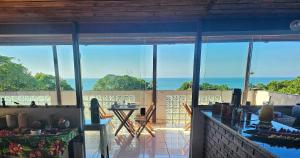 a living room with a view of the ocean at Pousada Encontro das Águas in Trindade