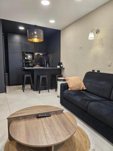 een woonkamer met een zwarte bank en een tafel bij le salon in Sablons