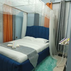 een slaapkamer met een blauw bed en een baldakijn bij Greenstar home in Kisii