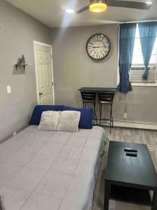 1 dormitorio con 1 cama y reloj en la pared en Cozy apartment 2 bedrooms, en Hillside