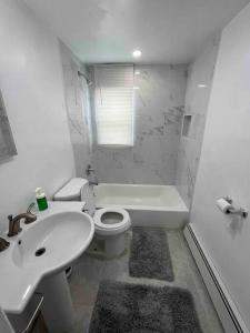 Baño blanco con lavabo y aseo en Cozy apartment 2 bedrooms, en Hillside