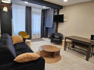 een woonkamer met een bank, een tafel en een piano bij le salon in Sablons