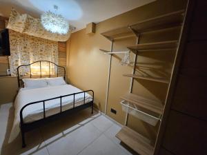 een kleine slaapkamer met een bed en een boekenplank bij le salon in Sablons