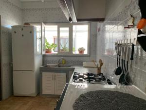 eine Küche mit einem Herd und einem weißen Kühlschrank in der Unterkunft Casa melo in Martil