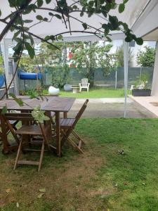 een picknicktafel en stoelen onder een tent bij Studio en rez-de jardin clos à 4km de l'aéroport et proche de toutes les commodités in Le Lamentin