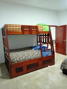 a bunk bed with a wooden bunk bed frame at Las Orquideas ( Rural house ) in Cumanda