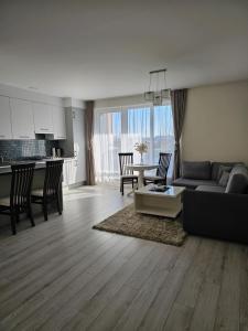 ein Wohnzimmer mit einem Sofa und einem Tisch sowie eine Küche in der Unterkunft Family apartment in Kretinga