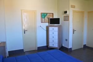 a bedroom with two doors and a tv on a dresser at Bahía - 30º hotels in Puerto de Mazarrón