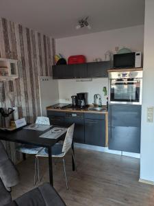 a kitchen with blue cabinets and a table with chairs at Kleine Seenadel in Dornumersiel