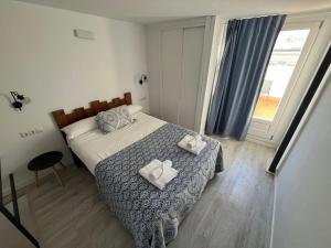 sypialnia z łóżkiem i dwoma ręcznikami na nim w obiekcie Penthouse La plaza en Cádiz Centro Grupo AC Gestion w Kadyksie