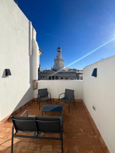 balkon z krzesłami i stołem oraz budynek w obiekcie Penthouse La plaza en Cádiz Centro Grupo AC Gestion w Kadyksie