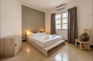 a bedroom with a large white bed and a window at We Call it Home - Bububu Villa in Mtoni