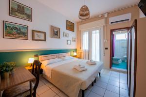 a bedroom with a bed and a table and a bathroom at La Villa in Cervia