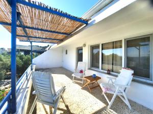 a patio with two chairs and a table on a balcony at ada-art guesthouse design rooms next to beach in Marmara Adasi