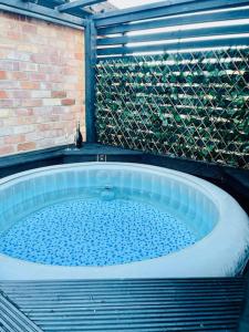 una grande vasca in un bagno con parete di mattoni di East Bridgford Coach House Inc Spa and Treatments a East Bridgford