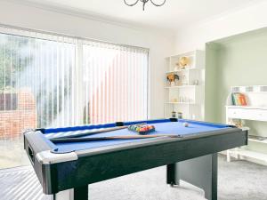 a pool table in a living room with at Zen 8-Bedroom Den in Edgbaston in Birmingham