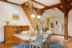 une salle à manger avec une table et un escalier dans l'établissement Galerie Haus Wohnung 1, à Sehestedt