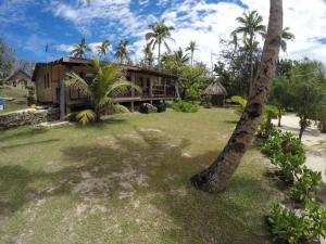 uma casa com uma palmeira em frente em Gold Coast Inn - Adults Only em Nanuya Lailai