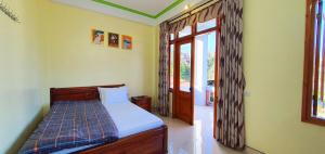 a bedroom with a bed and a sliding glass door at Đăng Dương Motel in Sa Pa