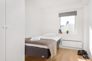 a small bedroom with a bed and a window at The Apartments Company - Majorstuen in Oslo