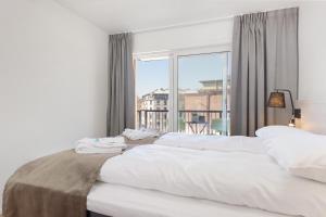 a bedroom with two beds and a large window at The Apartments Company - Majorstuen in Oslo