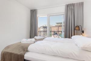 オスロにあるThe Apartments Company - Majorstuenのベッドルーム1室(ベッド2台、大きな窓付)