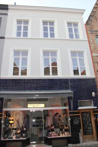 una tienda frente a un edificio blanco con ventanas en The Blue House, en Brujas