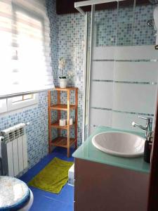 baño con lavabo blanco y azulejos azules en Casuca Montañesa en Santander, en Santander