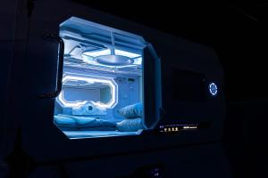 an open refrigerator with gloves and a blue light at Space Night Capsule Hostel in Berlin