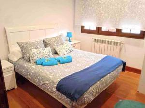 a bedroom with a large bed with blue pillows at Casuca Montañesa en Santander in Santander