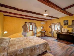 - une chambre avec un lit et un piano dans l'établissement Holiday House Kapitani, à Hum