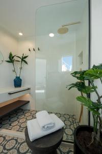 La salle de bains est pourvue d'une douche et d'une serviette sur un tabouret. dans l'établissement Big Blue Villa by Caldera Houses, à Oia