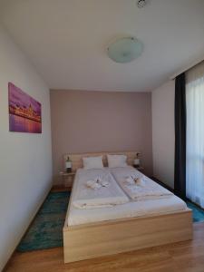 sypialnia z dużym łóżkiem z białą pościelą w obiekcie Corvin Plaza Apartments & Suites w Budapeszcie