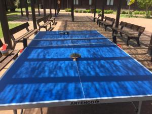 une grande table bleue avec bancs dans un parc dans l'établissement Cabañas bungalow, El Bosque de los Sueños, à Cubillos del Sil