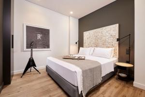 ein Schlafzimmer mit einem Bett und einem Stativ in der Unterkunft Viola Comfort Suite in Athen